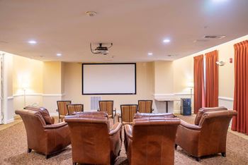 A room with a screen and chairs.